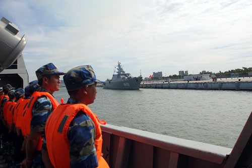 Thủy thủ đoàn HQ-011 đang thực hiện nghi thức chào cảng khi tàu tiến vào cầu tàu Trạm Giang; phía xa là HQ-012 đã cập cảng